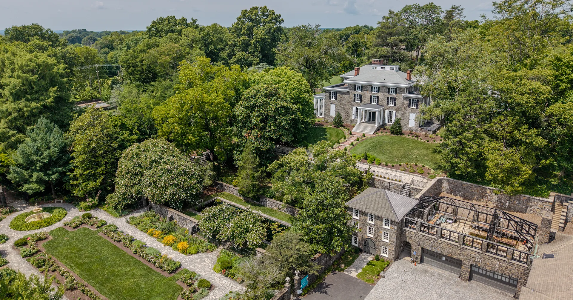 Aerial view of historic Delaware estate with gardens, showing full roofline and grounds